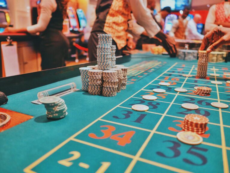A vibrant view of a casino roulette table with poker chips and players engaged in gambling.